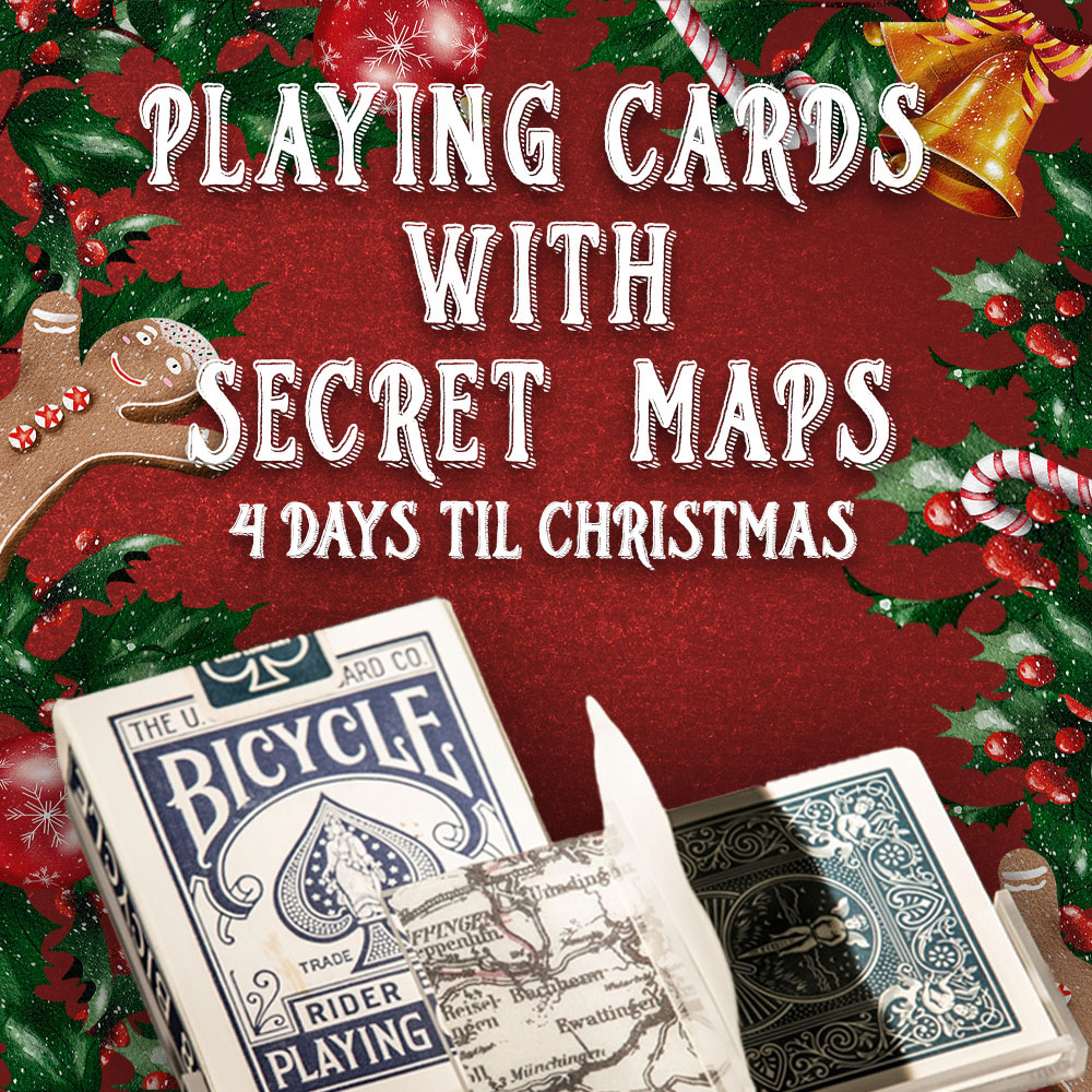 A deck of bicycle playing cards with one card being peeled back to reveal a map with a red background and christmas decor with text that reads 'playing cards with secret maps.'