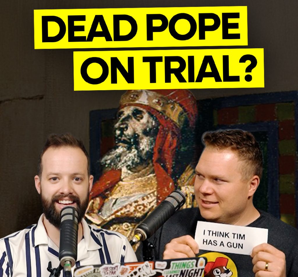A cadaver of a pope behind comedy podcasters jaron myers and tim stone and a banner that says 'dead pope on trial'